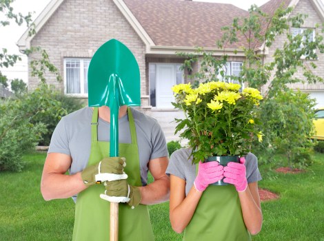 Garden maintenance crew performing pruning and lawn care in a suburban garden